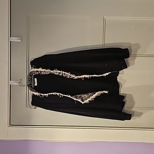 Black jacket with collard white print and ruffles. Sized large.